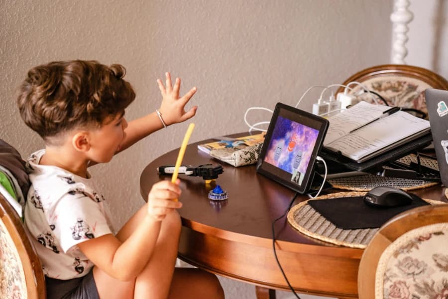 Child using an AAC device at a table
